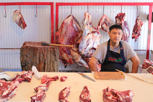 Meat shop and the owner in a market of Uzbekistan
